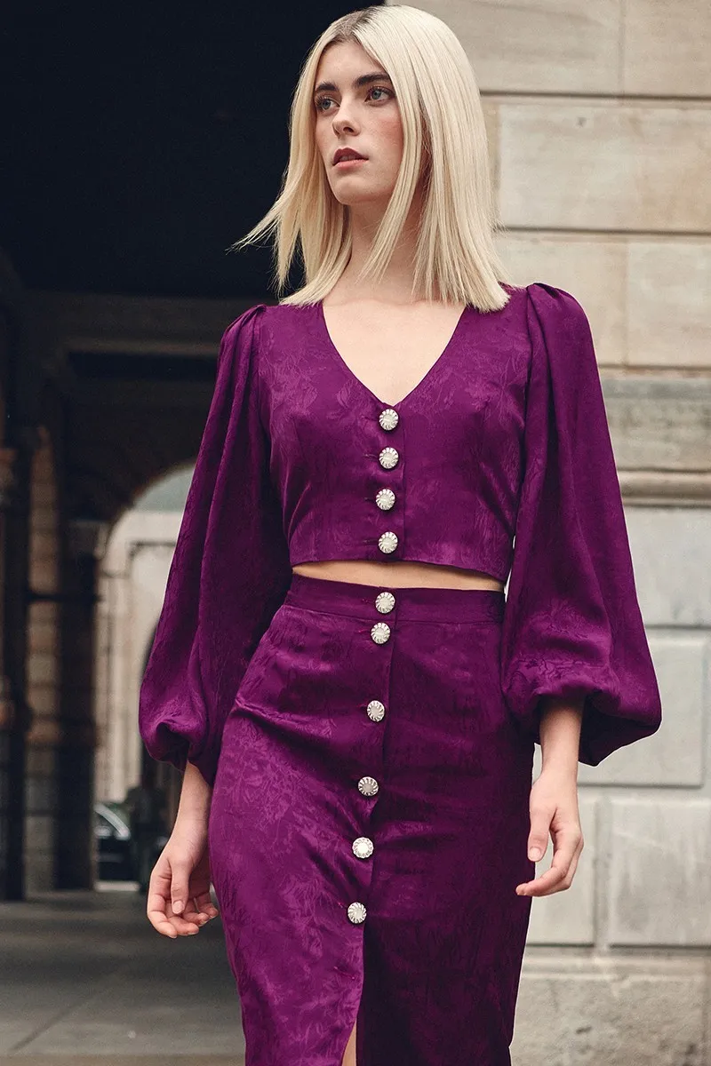 top morado con escote en pico boton joya y manga ablusonada