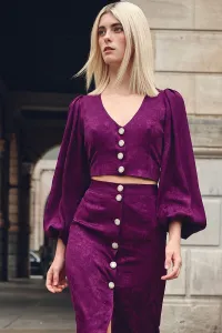 top morado con escote en pico boton joya y manga ablusonada