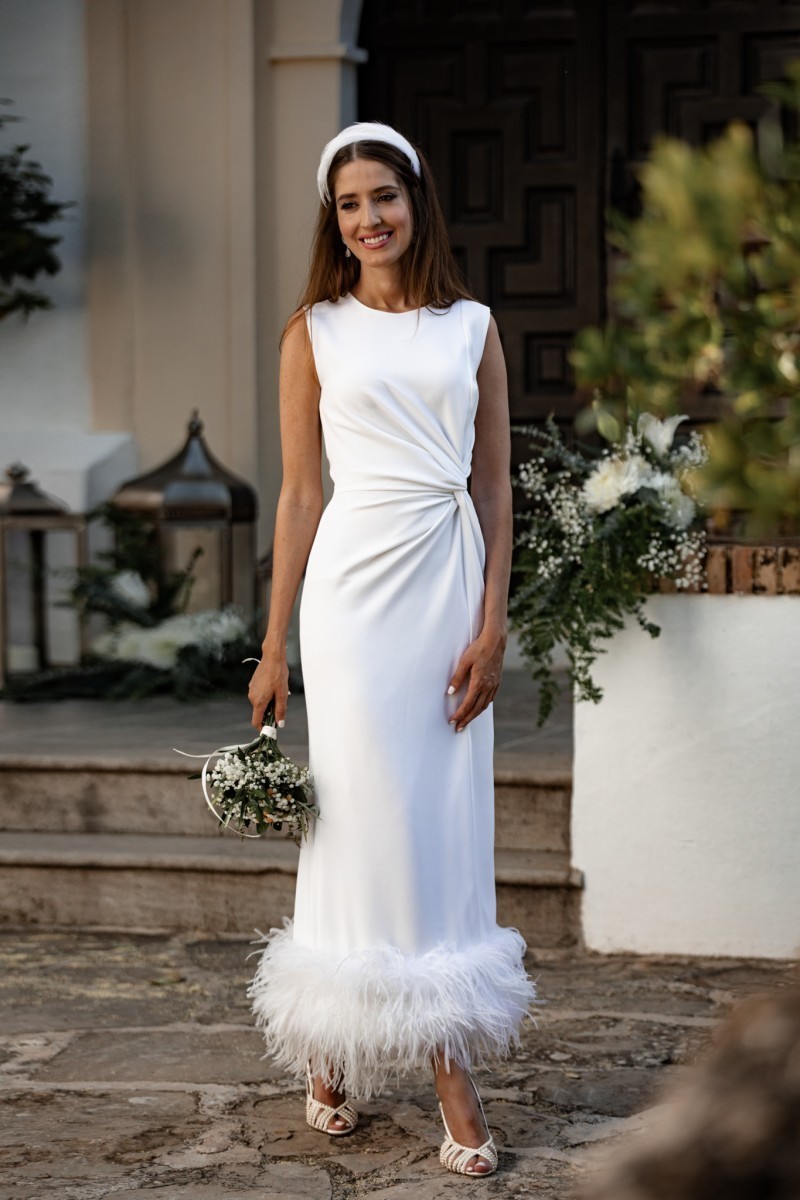 Vestido blanco midi fruncido en la cintura con pluma en el bajo