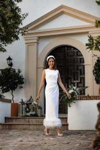 Vestido blanco midi fruncido en la cintura con pluma en el bajo