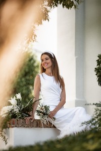 Vestido blanco midi fruncido en la cintura con pluma en el bajo