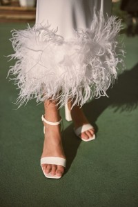 Vestido blanco midi fruncido en la cintura con pluma en el bajo