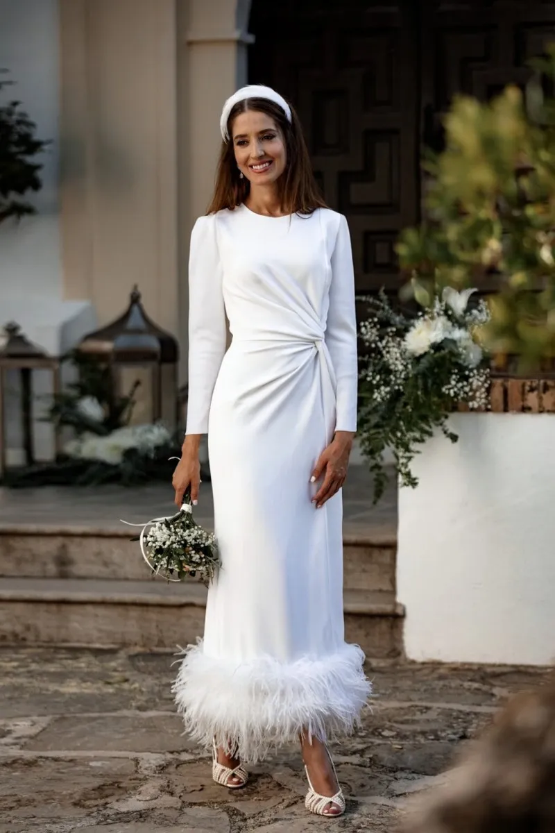 Vestido blanco midi fruncido en la cintura con pluma en el bajo
