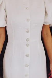 Vestido de pique blanco con boton joya y manga abullonada