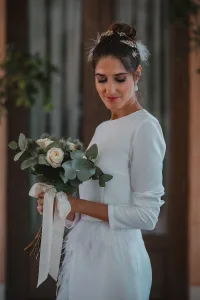 Vestido midi blanco con manga larga y pluma en cintura y falda