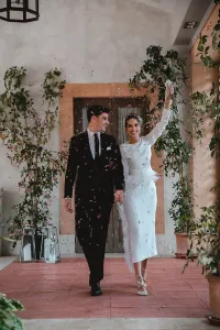Vestido midi blanco con manga larga y pluma en cintura y falda
