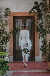 Vestido midi blanco con manga larga y pluma en cintura y falda