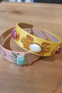 Diadema dorada con hojas y piedras facetadas blancas y frambuesas