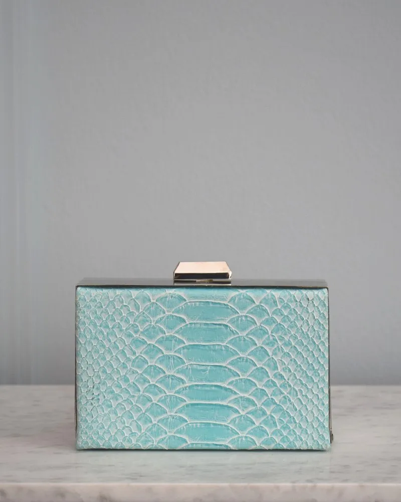 Bolso azul con joya de araña roja