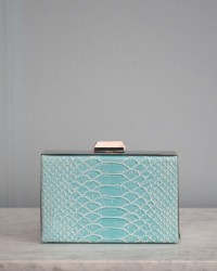 Bolso azul con joya de araña roja