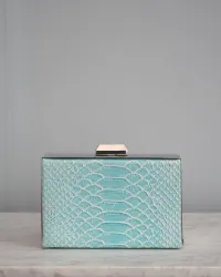 Bolso azul con joya de araña roja