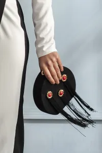 Bolso negro de ante con adornos dorados y rojos y flecos negros