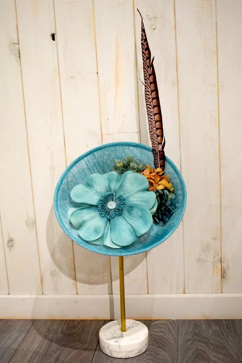 tocado azul claro con flor grande y pluma faisan