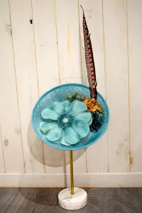 tocado azul claro con flor grande y pluma faisan
