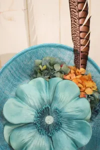 tocado azul claro con flor grande y pluma faisan