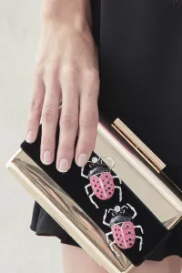 clutch de fiesta dorado con insecto joya rosa chicle y negro y