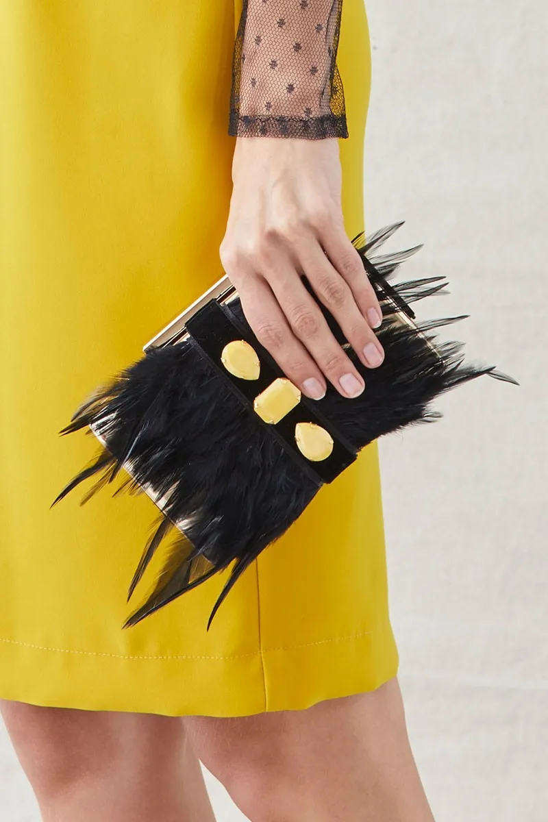 clutch de fiesta dorado con plumas negras y piedras amarillas