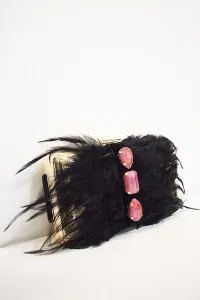 clutch de fiesta dorado con plumas negras y piedras amarillas