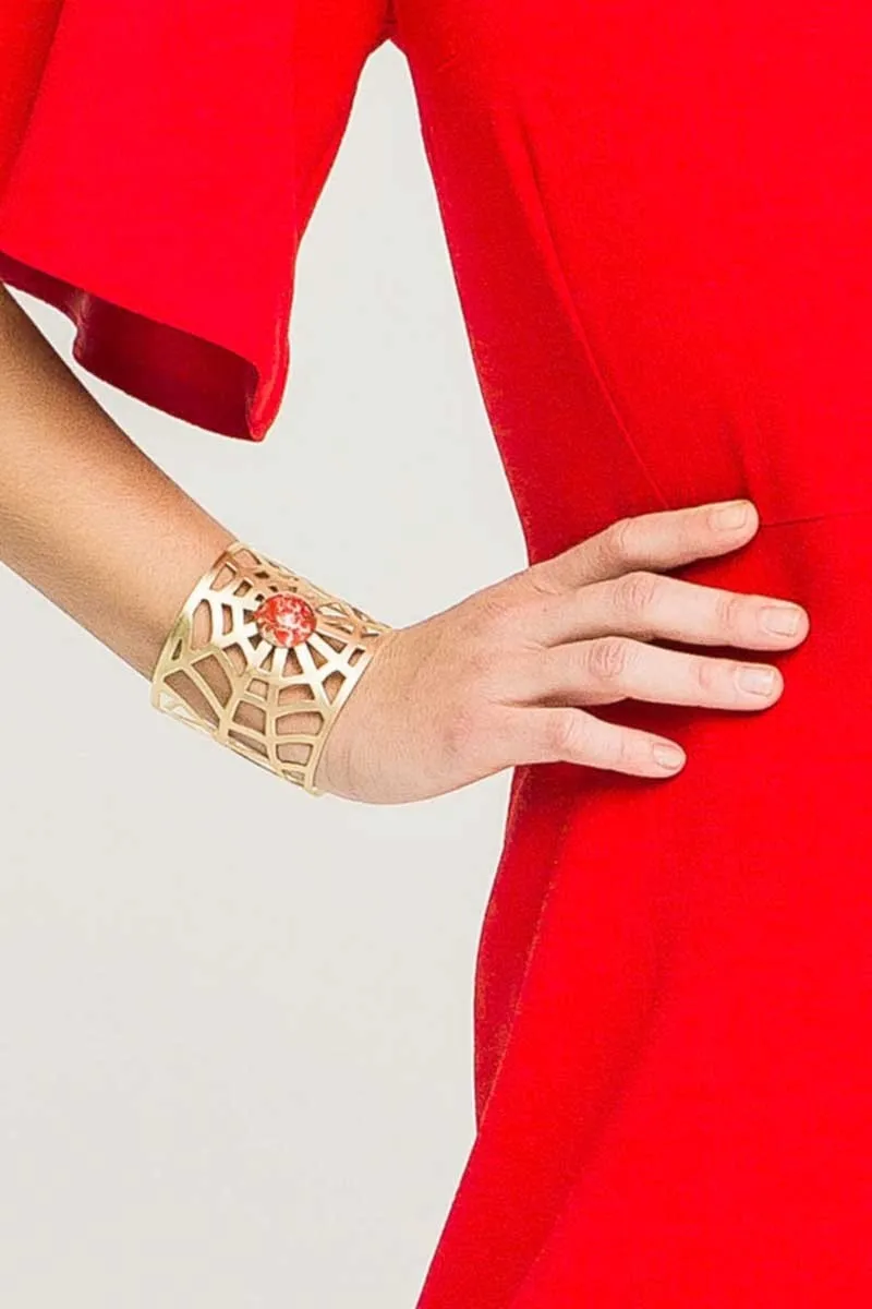 Brazalete dorado con forma de tela de arana y piedra roja