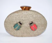 Bolso de fiesta de rafia con insectos joya en tonos coral y