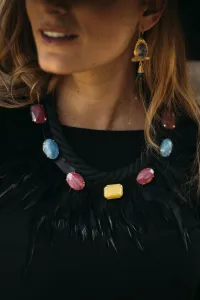Complemento de collar negro con plumas negras y predería de colores